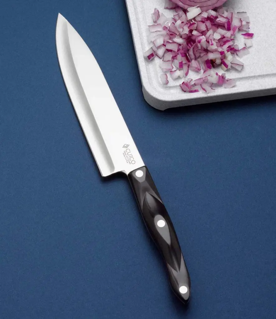 Elegant looking Cutco 8 Inch Chef Knife -Cutting Onions On White Wooden Board